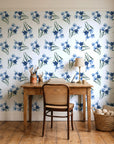 Sky Memory Midnight watercolor floral wallpaper behind a vintage writing desk in a cozy craft-room home office