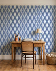 Smoke Ancestry Indigo geometric wallpaper behind a vintage writing desk in a cozy craft-room home office