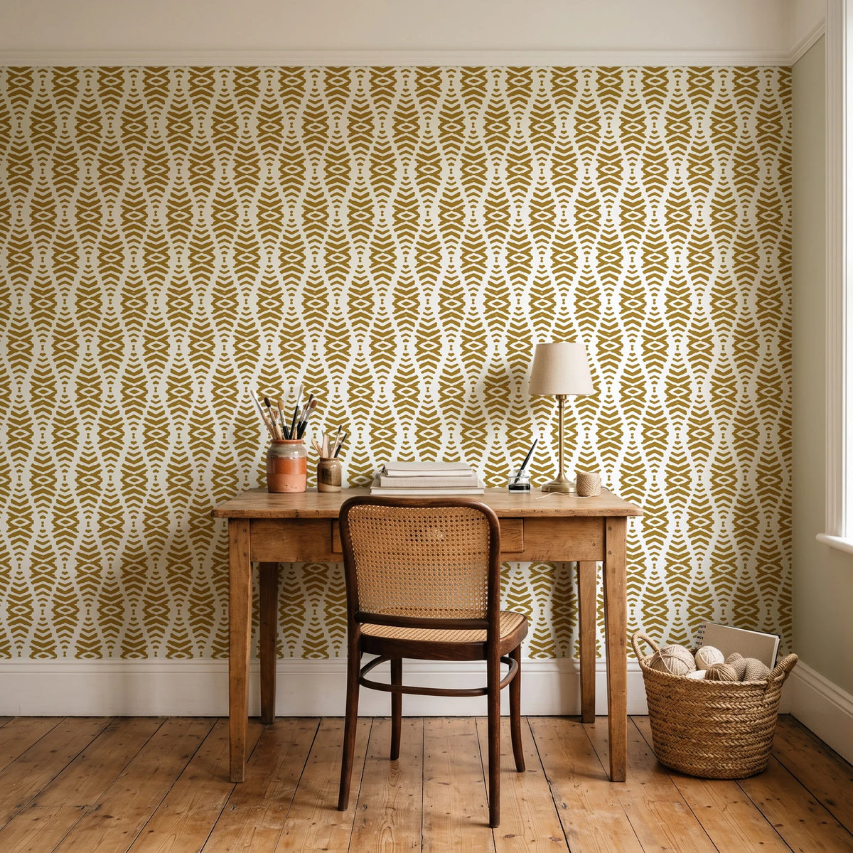 Smoke Ancestry Ochre geometric wallpaper behind a vintage writing desk in a cozy craft-room home office