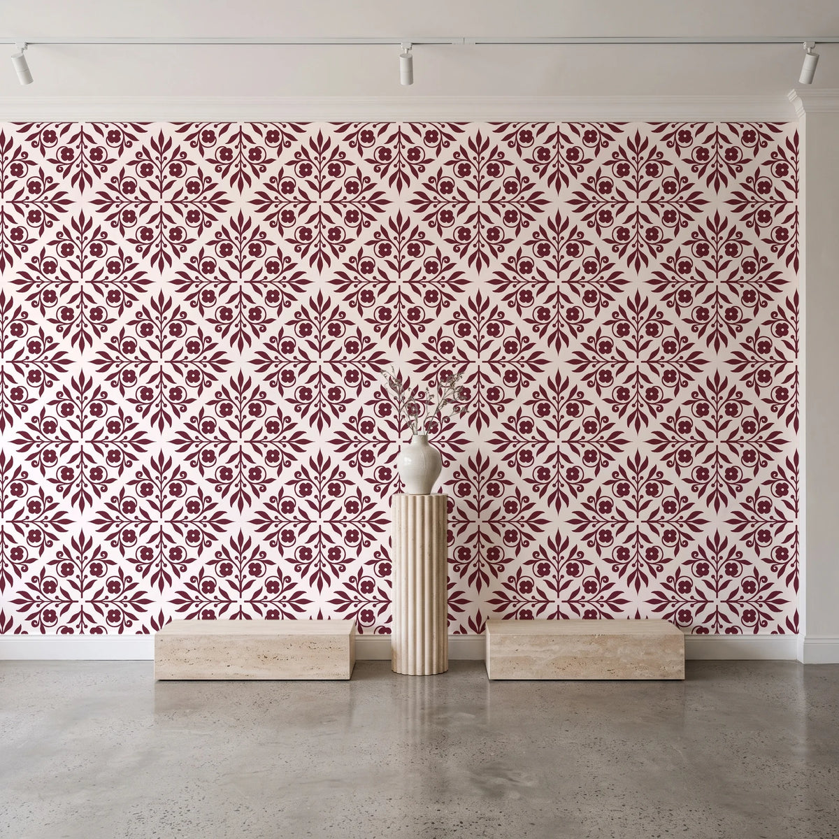 Soft Bouquet Opus Oxblood floral damask wallpaper behind a travertine pedestal and vase in a minimal boutique