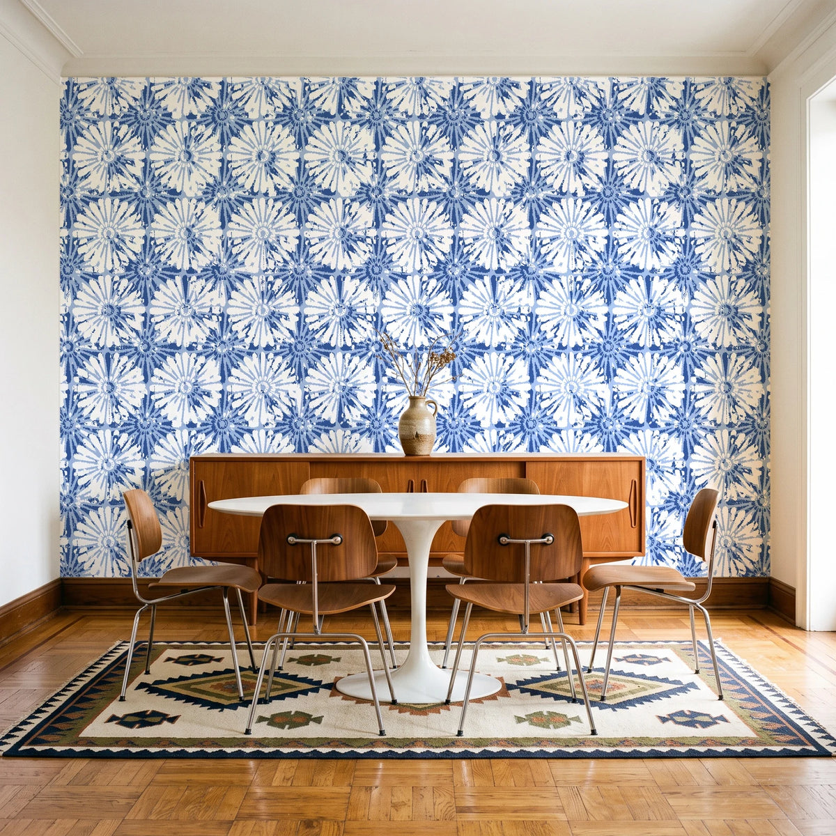Solar Ritual Indigo floral wallpaper in a mid-century dining room with a teak sideboard and tulip table