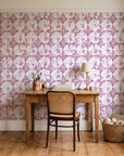Solar Ritual Rosewood floral wallpaper behind a vintage writing desk in a cozy craft-room home office