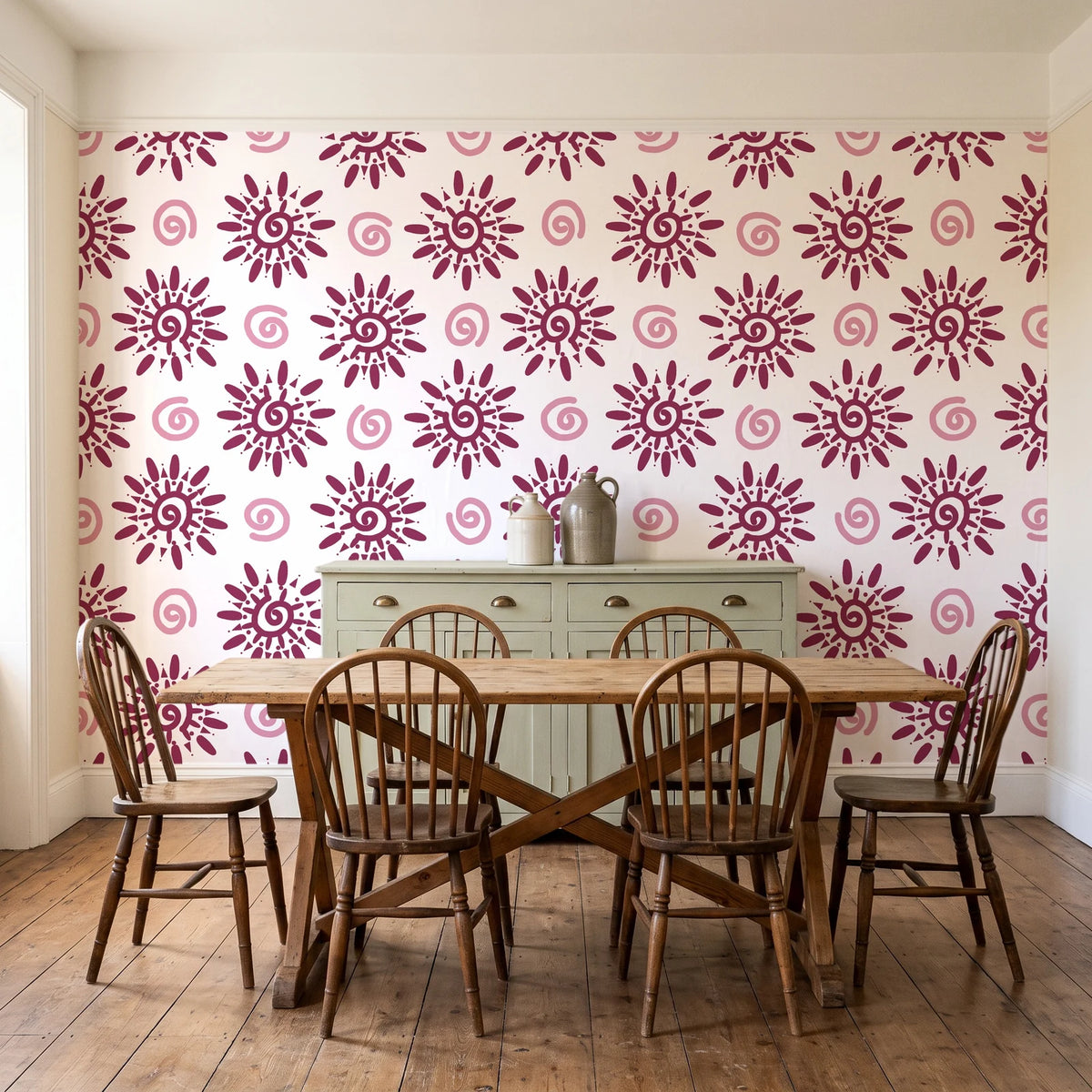 Solstice Bloom Berry folk sun wallpaper in a farmhouse dining room with a sage sideboard and rustic trestle table
