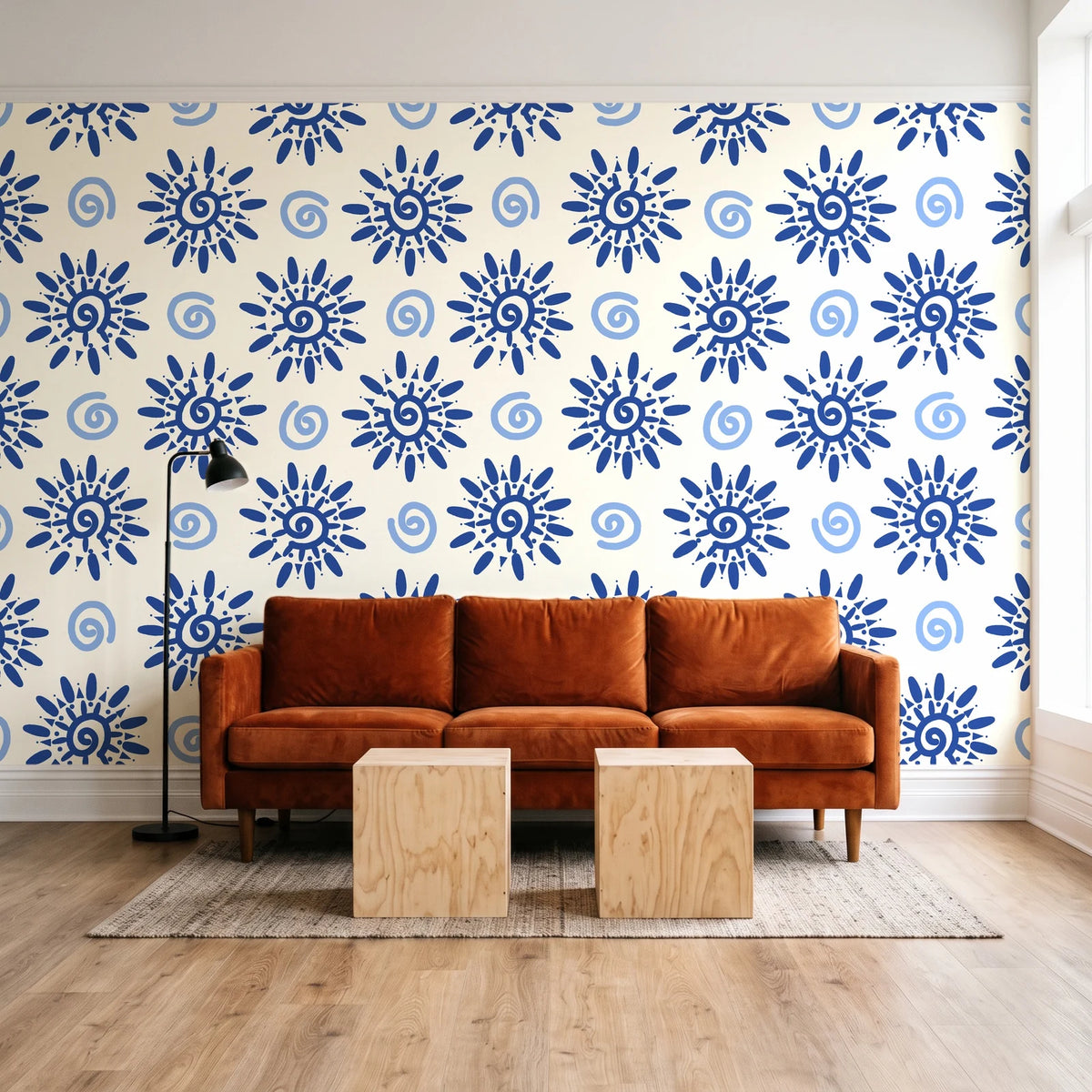 Solstice Bloom Cobalt folk sun wallpaper behind a rust velvet sofa in a bright coworking lounge