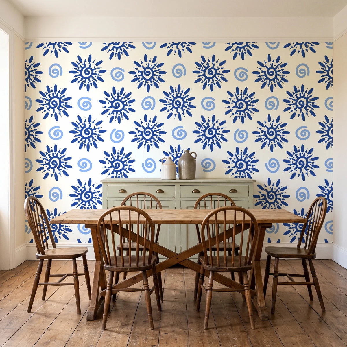 Solstice Bloom Cobalt folk sun wallpaper in a farmhouse dining room with a sage sideboard and rustic trestle table