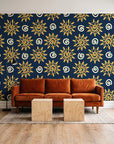 Solstice Bloom Midnight folk sun wallpaper behind a rust velvet sofa in a bright coworking lounge