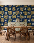 Solstice Bloom Midnight folk sun wallpaper in a farmhouse dining room with a sage sideboard and rustic trestle table