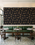 Solstice Rite Eclipse boho rainbow wallpaper above a green leather banquette in a sunlit neighborhood cafe