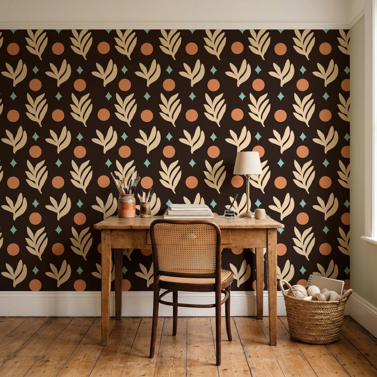 Spice & Frond Espresso leaf frond wallpaper behind a vintage writing desk in a cozy craft-room home office