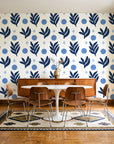 Spice & Frond Indigo leaf frond wallpaper in a mid-century dining room with a teak sideboard and tulip table