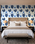 Spice & Frond Indigo leaf frond wallpaper behind the headboard of a king bed in a contemporary hotel guest room