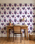 Spice & Frond Plum leaf frond wallpaper behind a vintage writing desk in a cozy craft-room home office