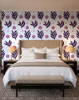 Spice & Frond Plum leaf frond wallpaper behind the headboard of a king bed in a contemporary hotel guest room