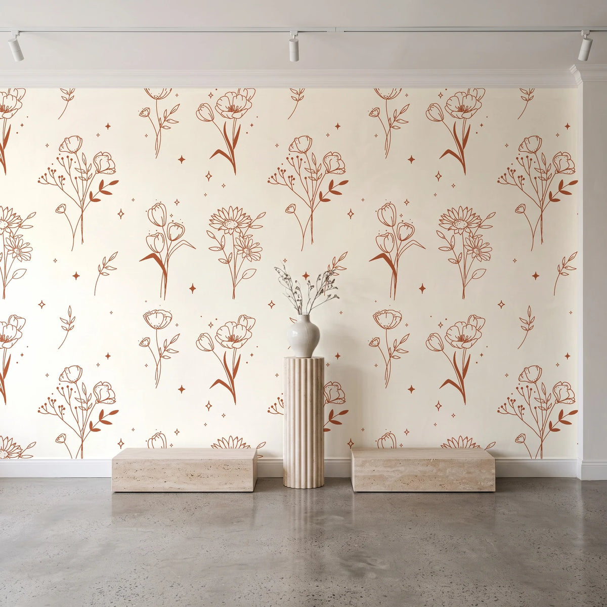 Stardust Field Terracotta wildflower line art wallpaper behind a travertine pedestal and vase in a minimal boutique
