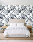 Starfall Charcoal watercolor leaf wallpaper behind a queen bed in a bright coastal bedroom