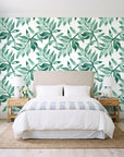 Starfall Emerald watercolor leaf wallpaper behind a queen bed in a bright coastal bedroom