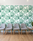 Starfall Emerald watercolor leaf wallpaper behind a row of upholstered chairs in a bright clinic waiting room