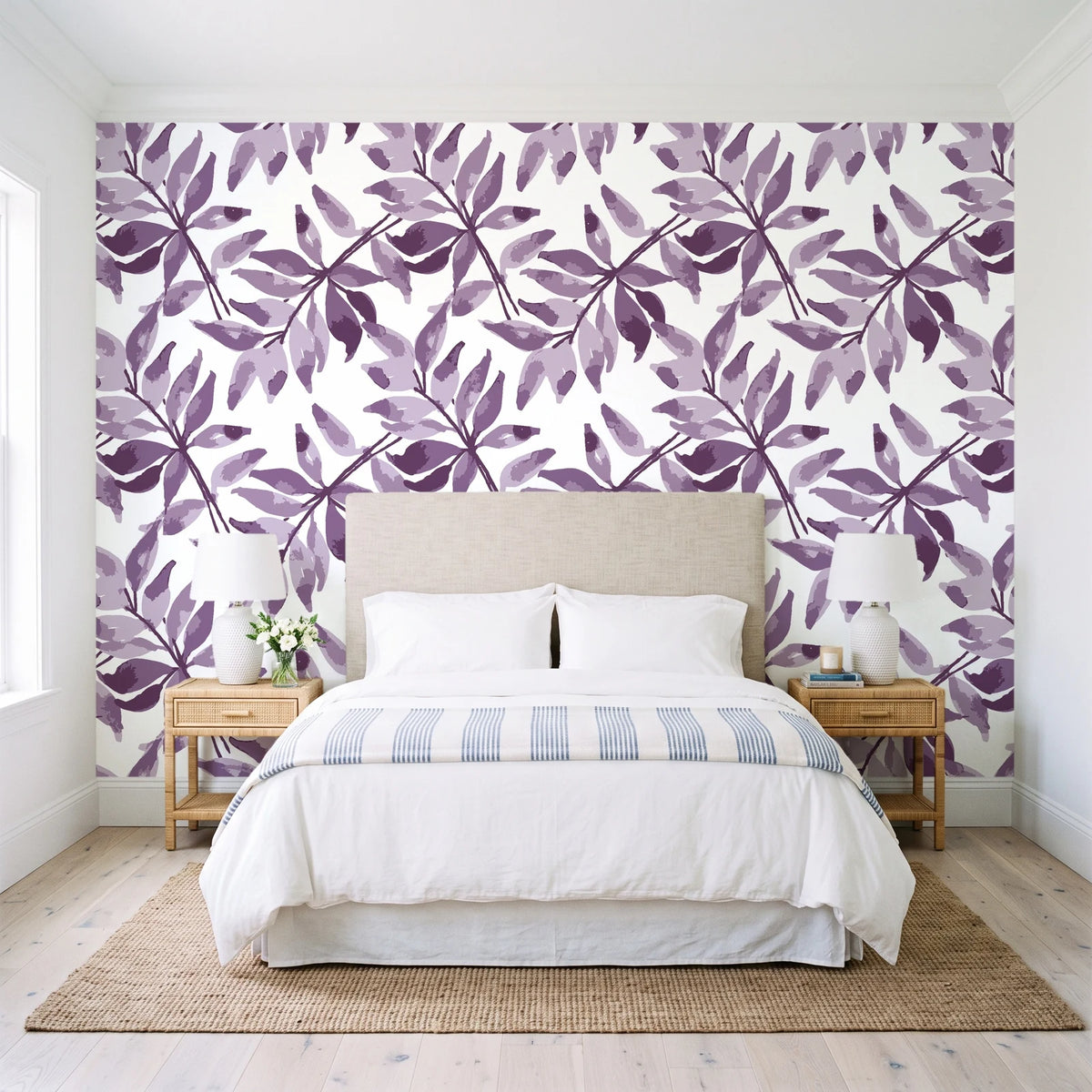 Starfall Plum watercolor leaf wallpaper behind a queen bed in a bright coastal bedroom