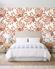 Starfall Terracotta watercolor leaf wallpaper behind a queen bed in a bright coastal bedroom