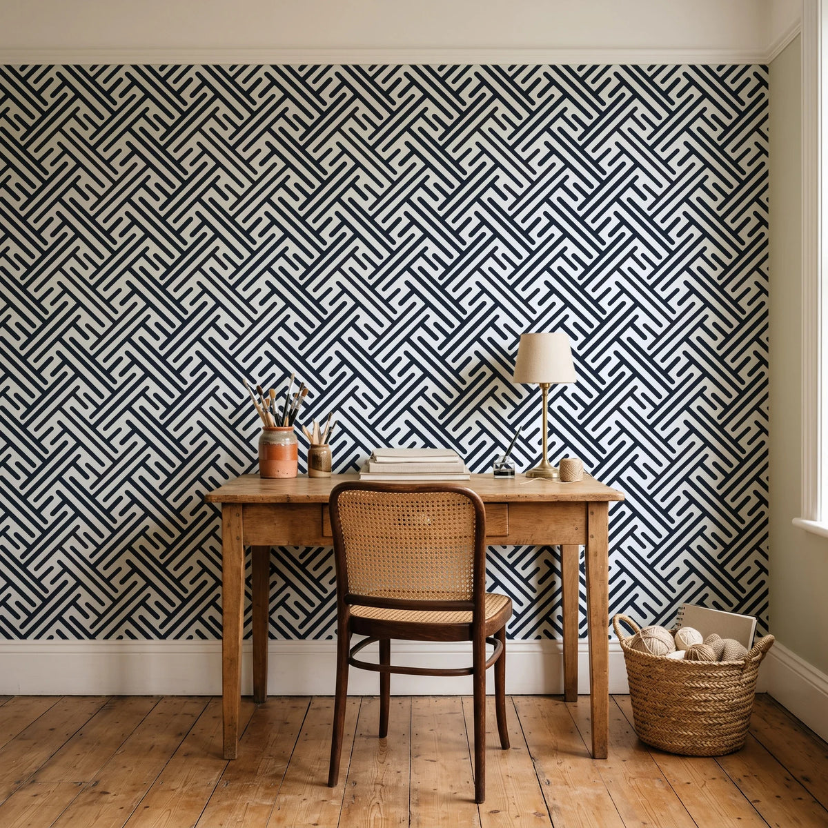 Still Labyrinth Ink maze geometric wallpaper behind a vintage writing desk in a cozy craft-room home office