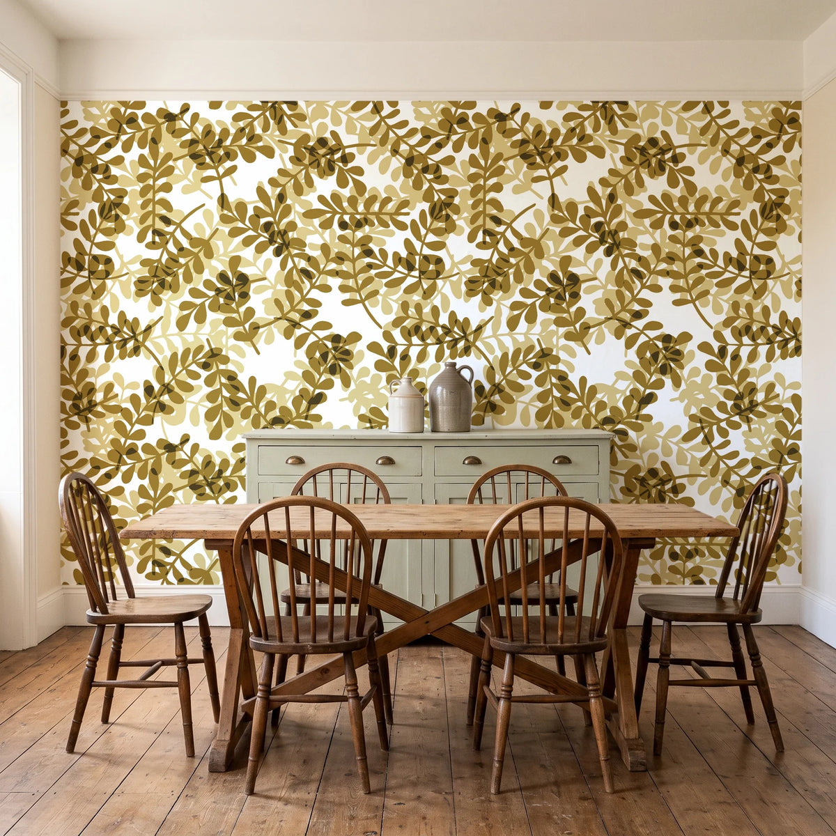 Still Morning Ochre foliage wallpaper in a farmhouse dining room with a sage sideboard and rustic trestle table