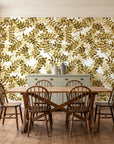 Still Morning Ochre foliage wallpaper in a farmhouse dining room with a sage sideboard and rustic trestle table