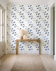 Stone Garden Navy sprig wallpaper behind a console table in a light entry hallway