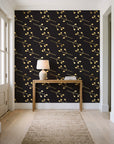 Stone Garden Noir sprig wallpaper behind a console table in a light entry hallway