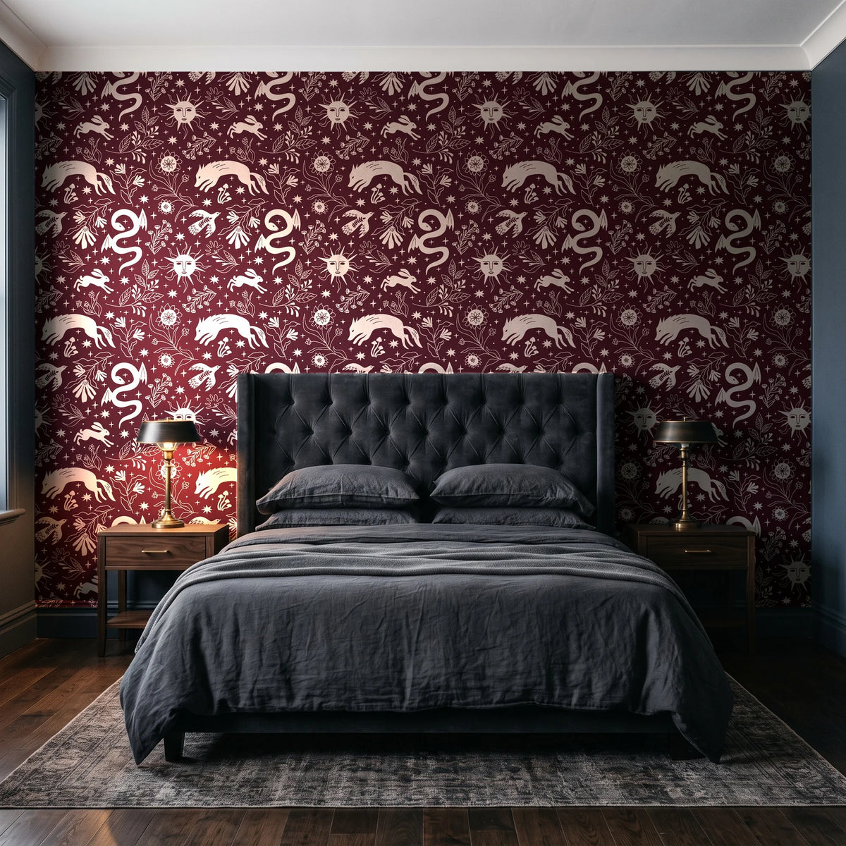 Sun & Moon Oxblood celestial folk wallpaper behind a tufted headboard in a dark, moody bedroom