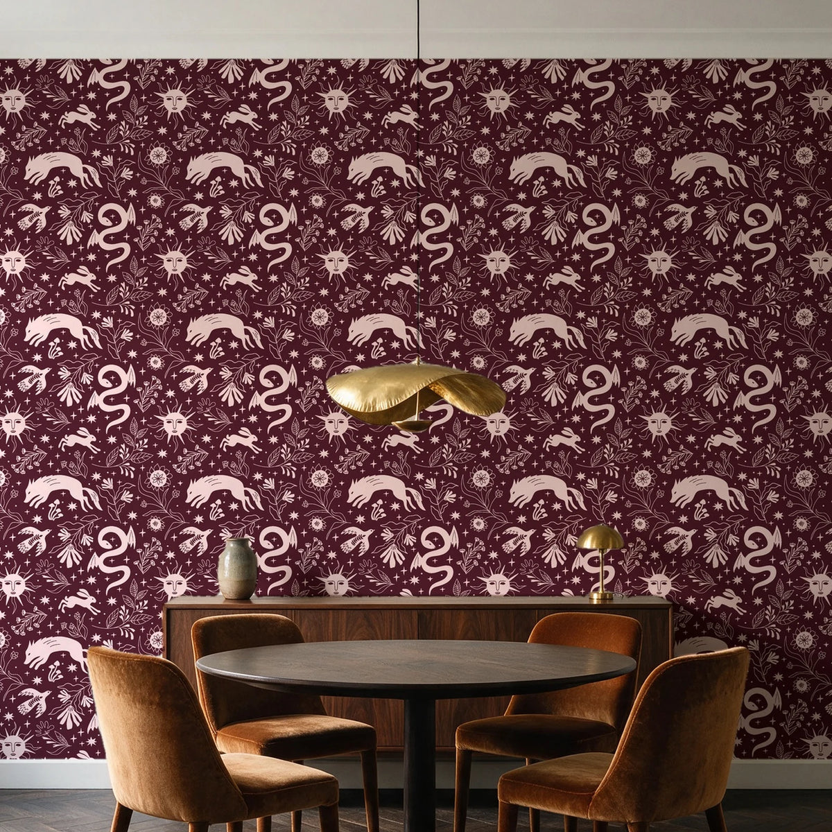 Sun & Moon Oxblood celestial folk wallpaper behind a walnut credenza and round table in an elegant dining room
