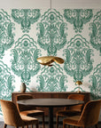 Sunlit Thicket Emerald damask wallpaper behind a walnut credenza and round table in an elegant dining room