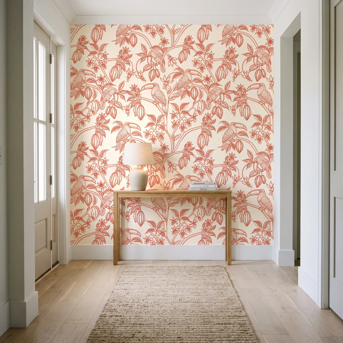 Toucan Toile Coral tropical bird wallpaper behind a console table in a light entry hallway
