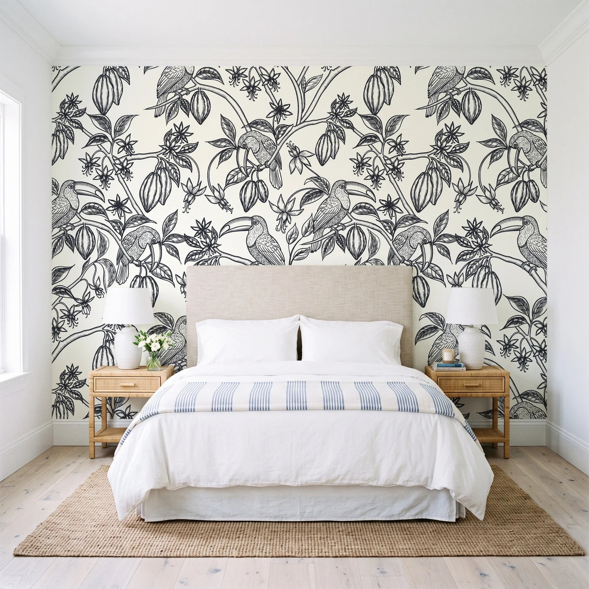 Toucan Toile Ink tropical bird wallpaper behind a queen bed in a bright coastal bedroom