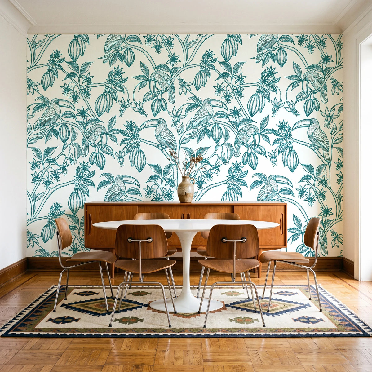 Toucan Toile Teal tropical bird wallpaper in a mid-century dining room with a teak sideboard and tulip table