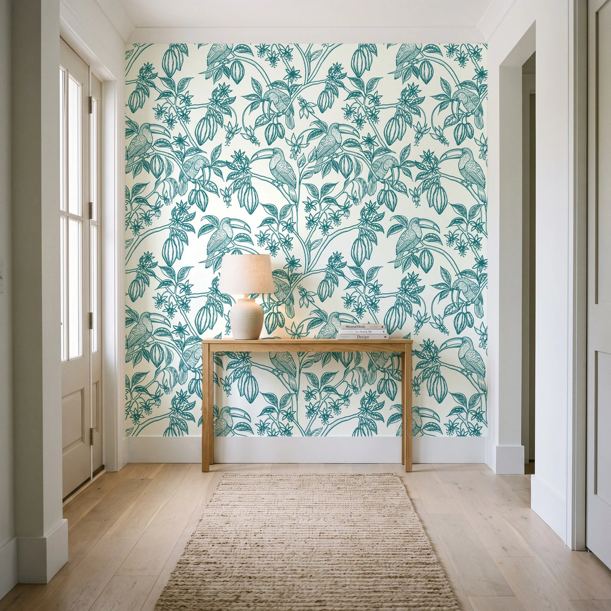 Toucan Toile Teal tropical bird wallpaper behind a console table in a light entry hallway