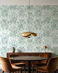 Tranquil Flora Sage floral damask wallpaper behind a walnut credenza and round table in an elegant dining room