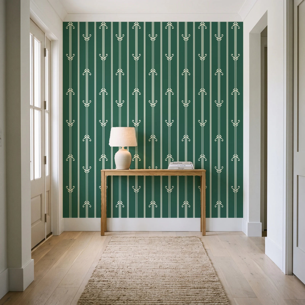 Tranquility Tapestry Emerald art deco stripe wallpaper behind a console table in a light entry hallway