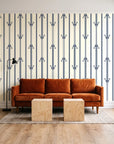 Tranquility Tapestry Midnight art deco stripe wallpaper behind a rust velvet sofa in a bright coworking lounge