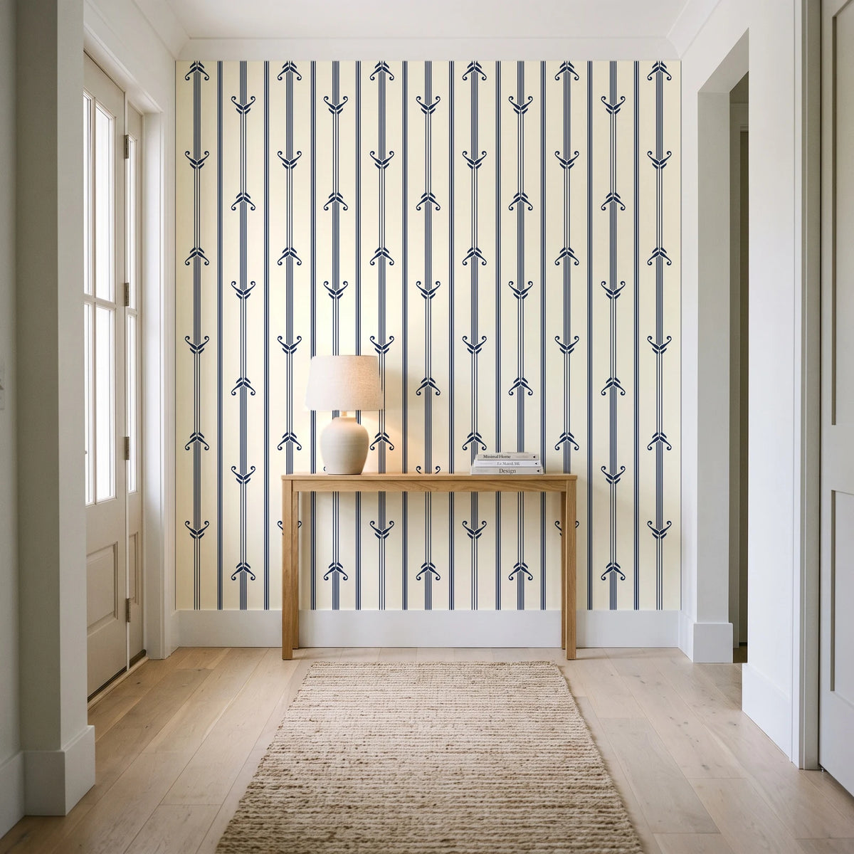 Tranquility Tapestry Midnight art deco stripe wallpaper behind a console table in a light entry hallway