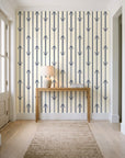 Tranquility Tapestry Midnight art deco stripe wallpaper behind a console table in a light entry hallway