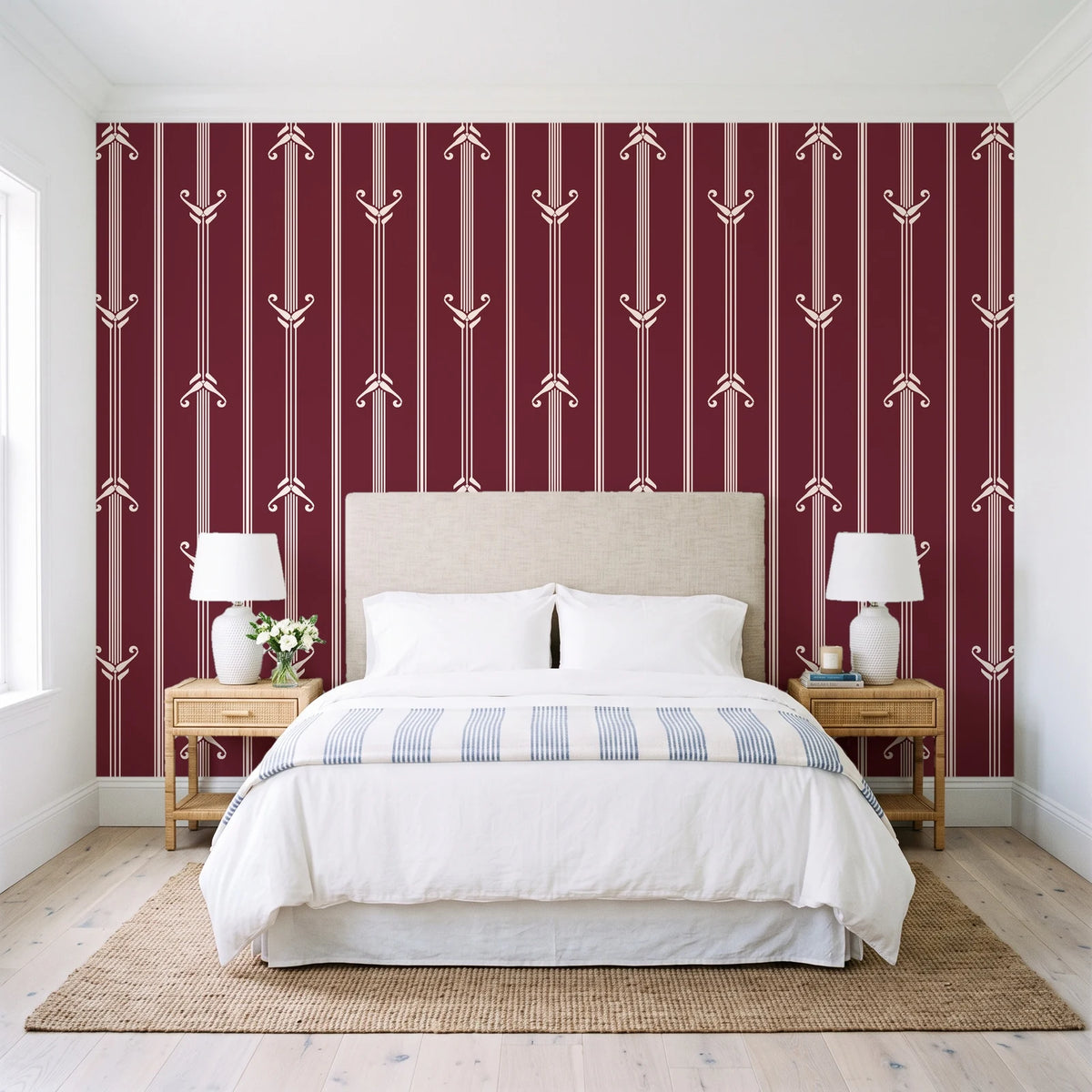 Tranquility Tapestry Oxblood art deco stripe wallpaper behind a queen bed in a bright coastal bedroom