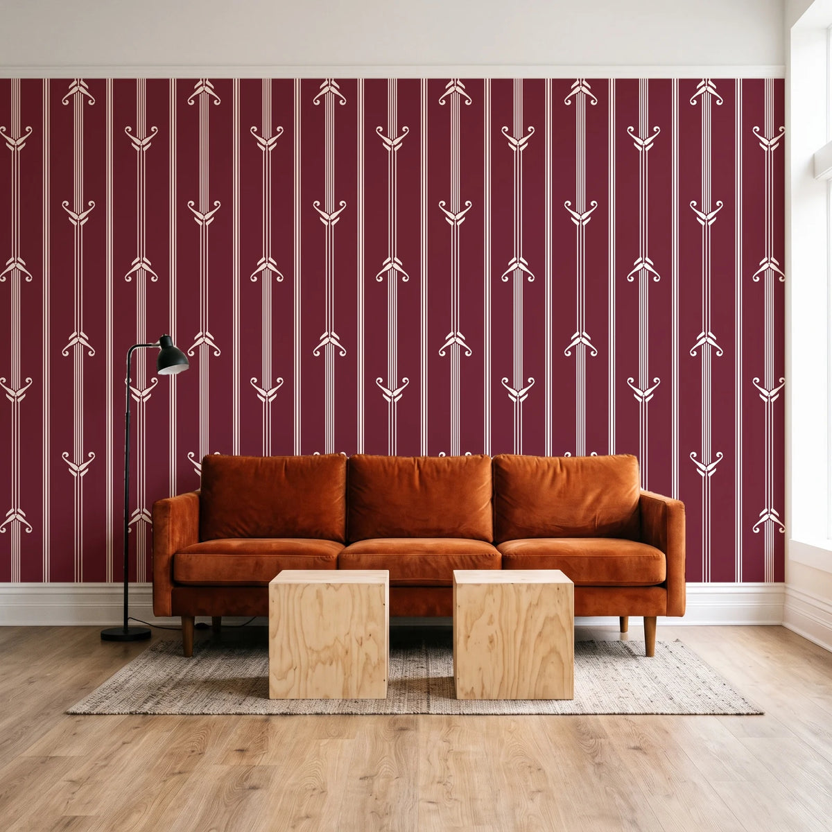 Tranquility Tapestry Oxblood art deco stripe wallpaper behind a rust velvet sofa in a bright coworking lounge
