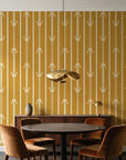Tranquility Tapestry Saffron art deco stripe wallpaper behind a walnut credenza and round table in an elegant dining room
