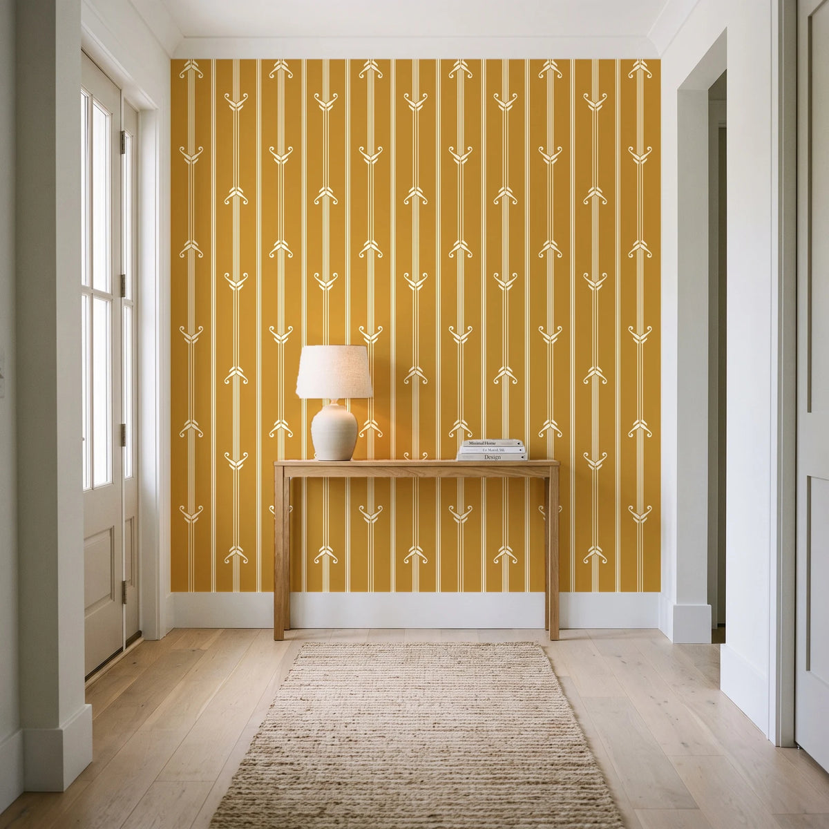 Tranquility Tapestry Saffron art deco stripe wallpaper behind a console table in a light entry hallway