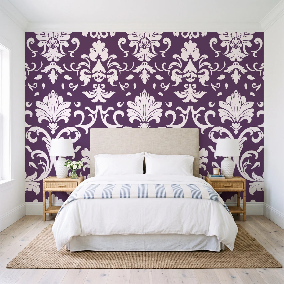 Twilight Garden Veil Plum damask wallpaper behind a queen bed in a bright coastal bedroom