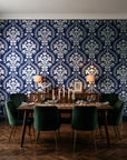 Veiled Botany Navy damask wallpaper in a dark moody dining room with a candlelit table