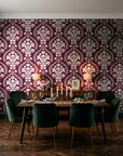 Veiled Botany Oxblood damask wallpaper in a dark moody dining room with a candlelit table