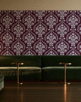 Veiled Botany Oxblood damask wallpaper in an intimate luxury cocktail lounge