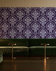 Veiled Botany Plum damask wallpaper in an intimate luxury cocktail lounge