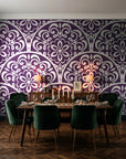 Velvet Vine Serenade Plum damask wallpaper in a dark moody dining room with a candlelit table